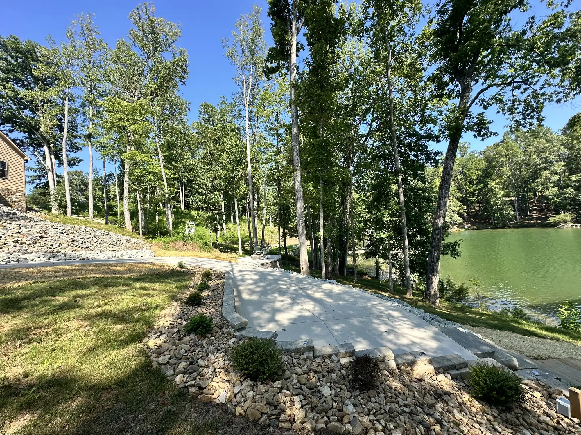 Landscaped lakeside property with concrete path, lawn, and stone borders at Smith Mountain Lake
