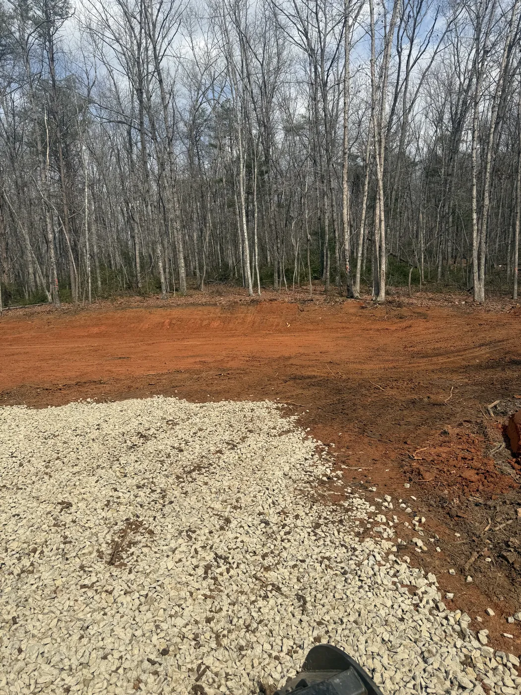 Gravel area meeting cleared red clay at barndominium site