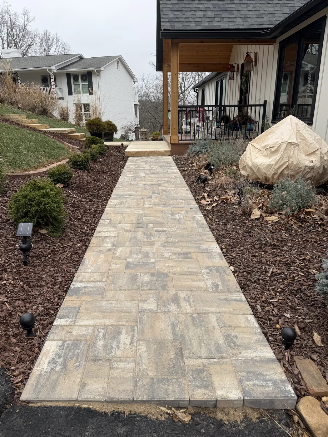 Paver walkway leading to front porch with landscape lighting at Hunting Hill