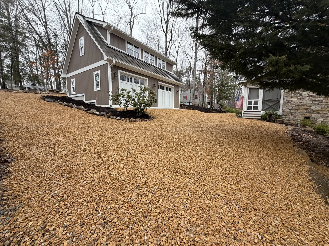 Detached garage with gravel driveway and mulch landscaping at Patmos Church
